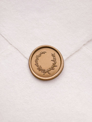 Delicate botanical wreath gold wax seal on a white handmade paper envelope