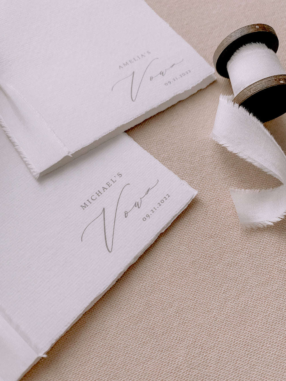 white handmade paper vow books personalized with the couple's names and wedding date