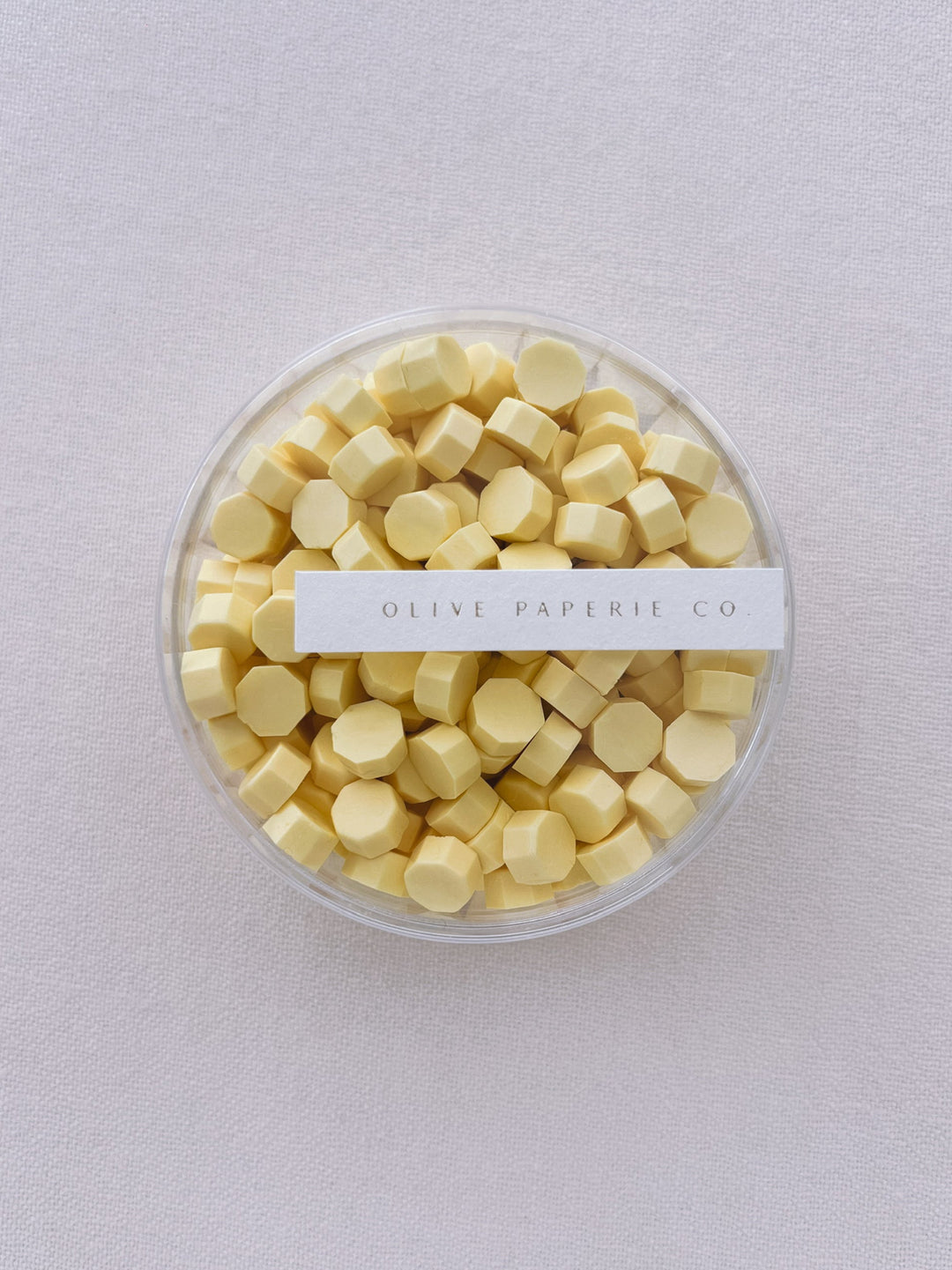 pastel butter yellow sealing wax beads in a clear container box