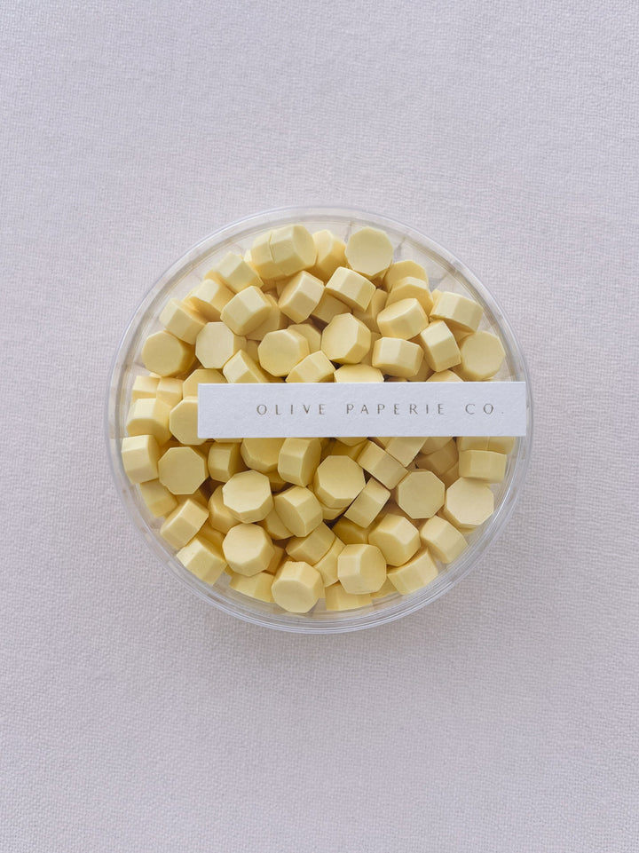 pastel butter yellow sealing wax beads in a clear container box