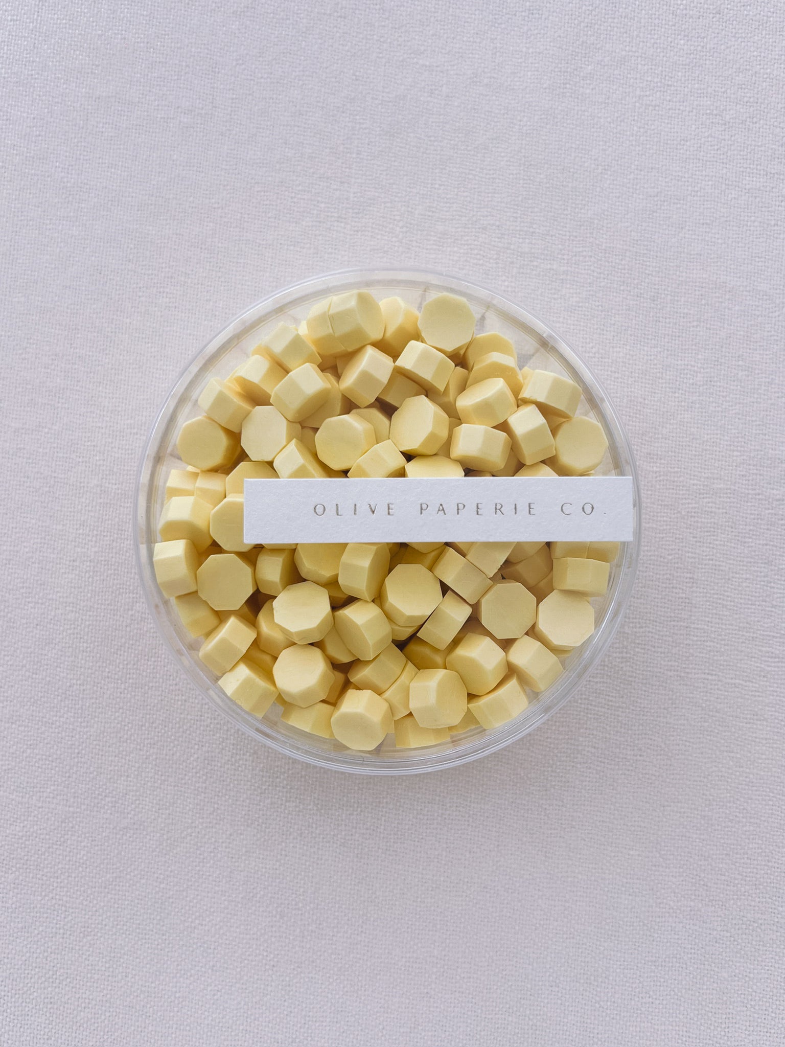 pastel butter yellow sealing wax beads in a clear container box