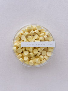 pastel butter yellow sealing wax beads in a clear container box