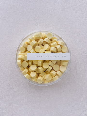 pastel butter yellow sealing wax beads in a clear container box