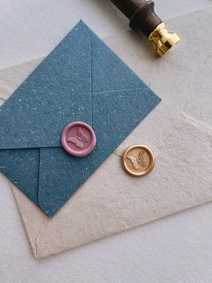 3D mini butterfly wax seals on blue and beige envelopes 