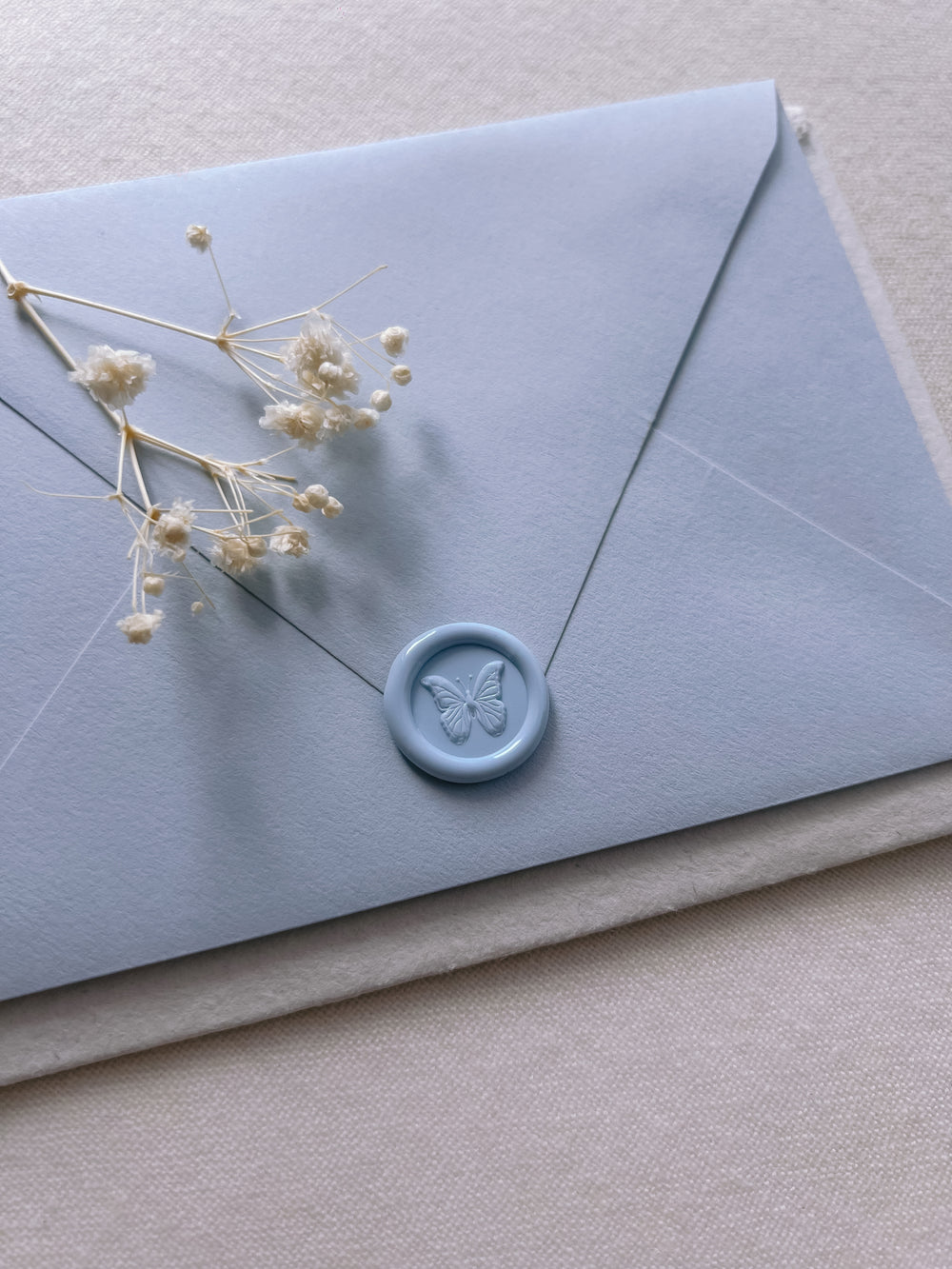 3D butterfly light blue mini wax seal on light blue envelope 