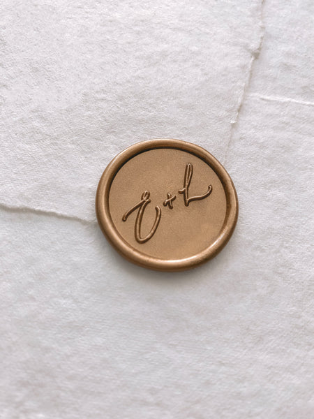 Calligraphy script monogram round wax seal in gold on handmade paper envelope_side angle