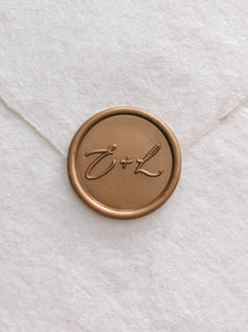 Calligraphy script monogram round wax seal in gold on handmade paper envelope_front angle
