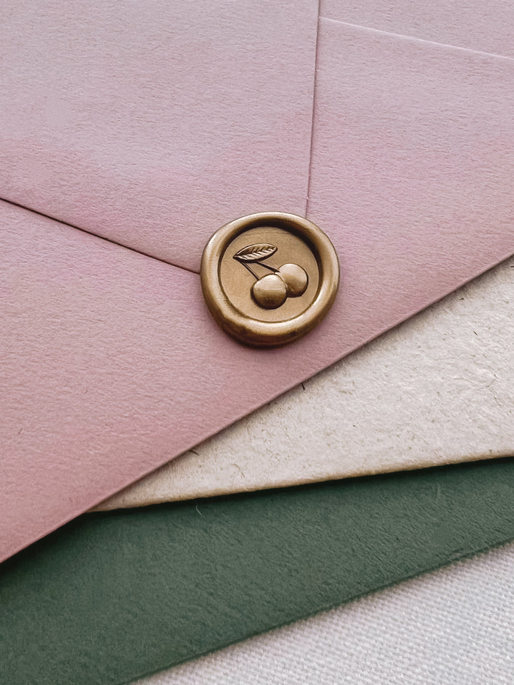 cherry emoji mini gold wax seal on a pink envelope