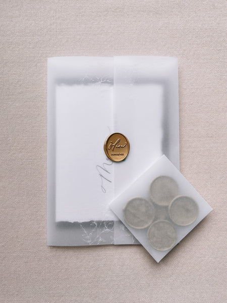 Handmade Christmas card wrapped in printed vellum wrap with gold wax seals in a small vellum envelope