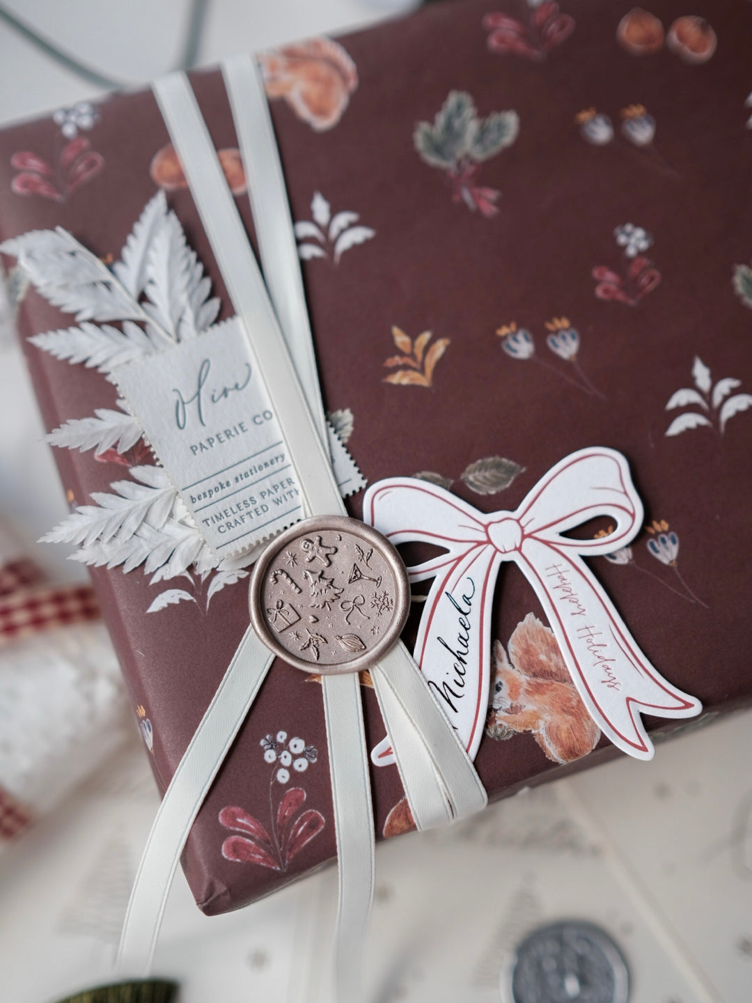Wrapped Christmas gift decorated with light bronze festive icon wax seal 