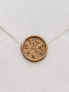 gold Christmas wax seal with festive icons and symbols like Christmas tree, gingerbread man, snowflake, holly and candy cane 