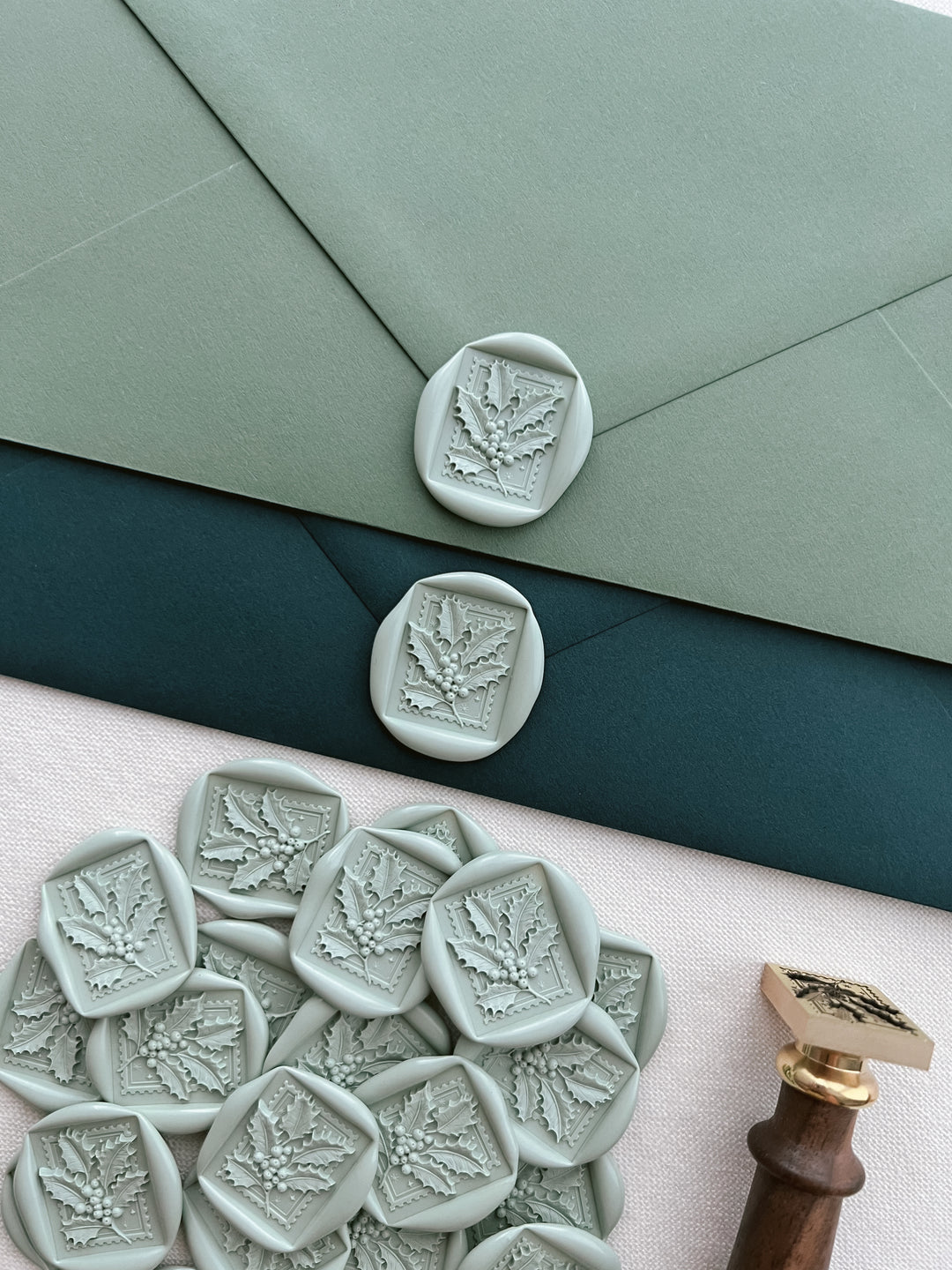 light green Christmas holly leaf wax seals on green Christmas card envelopes