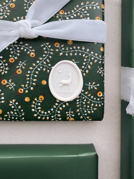 white Christmas reindeer wax seal on festive holiday gift wrap