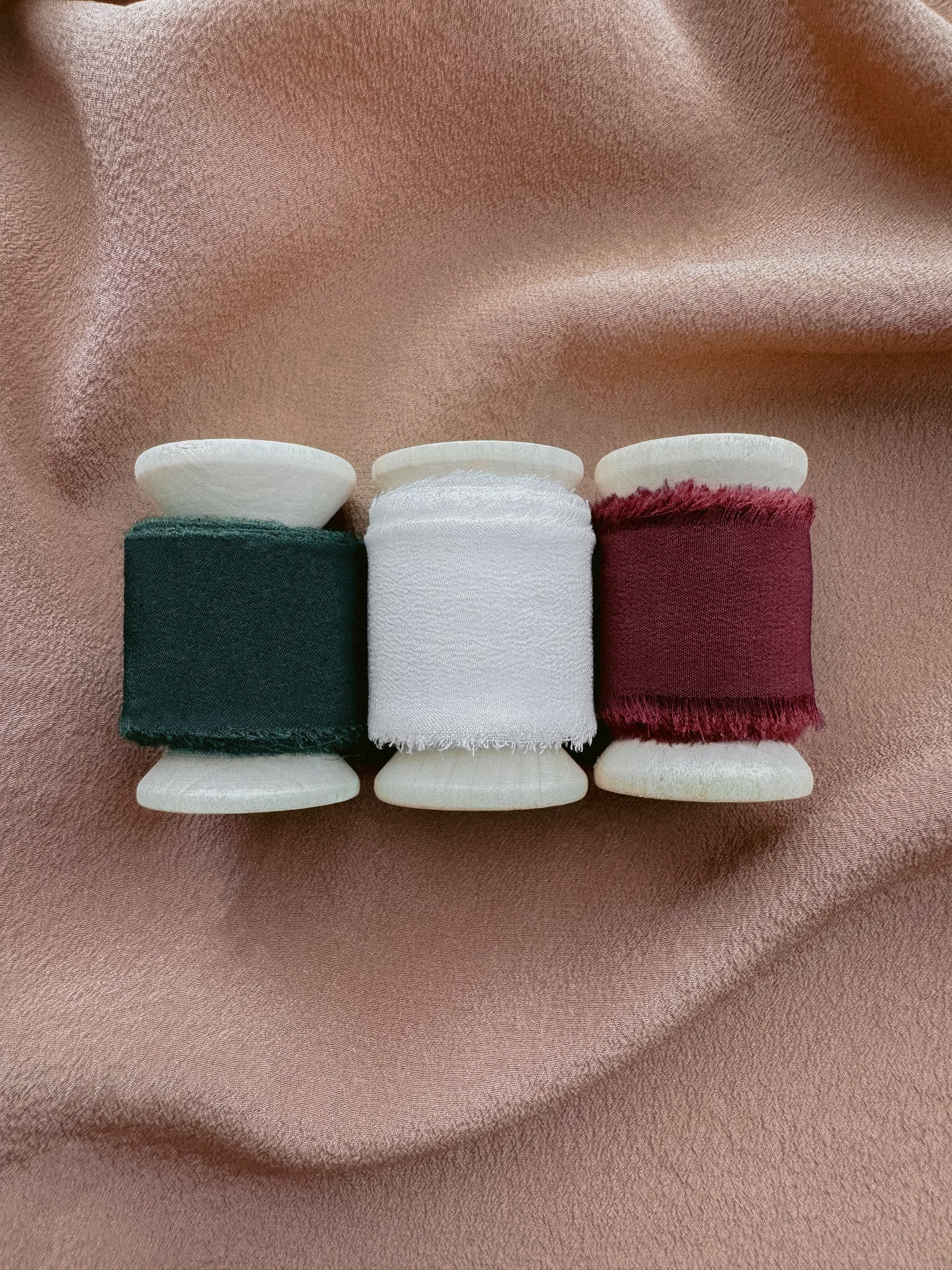 set of three silk ribbon in festive Christmas colors, dark green, red and white