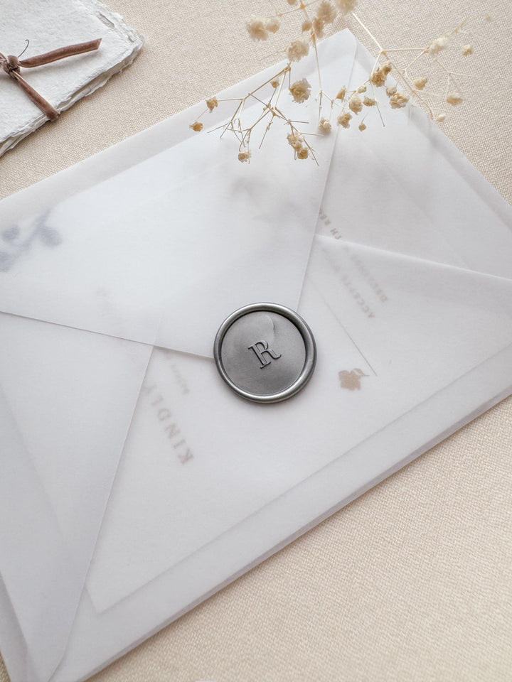 personalised initial silver wax seal on a vellum wedding invitation envelope