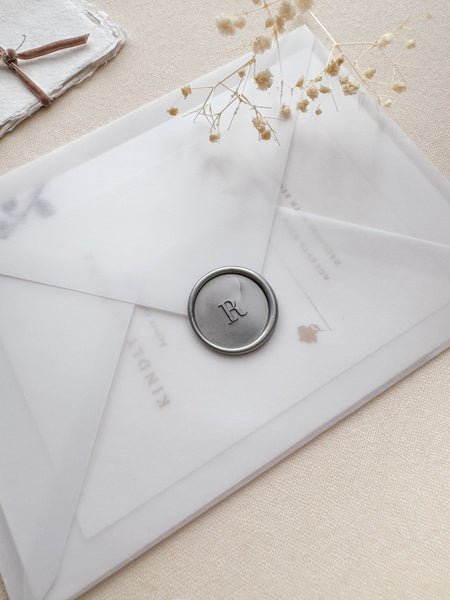 custom initial silver wax seal on a vellum wedding invitation envelope