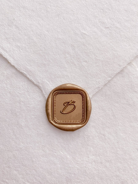 Border mini square single initial custom wax seal in gold on beige handmade paper envelope