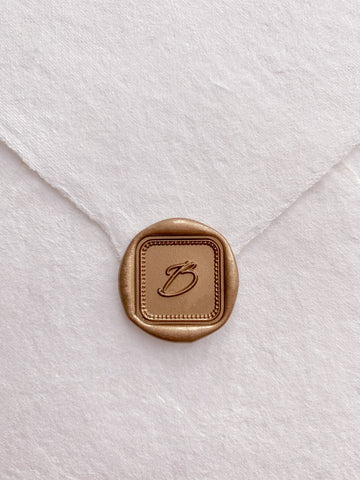 Single initial with border design mini square gold custom wax seal on beige handmade paper envelope