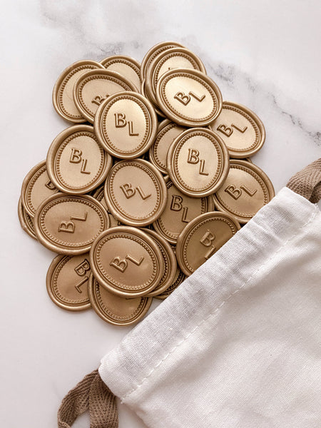 Border monogram oval gold custom wax seals in gold in white linen pouch 