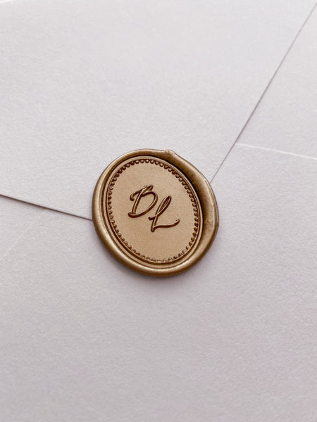 Calligraphy script monogram with border design oval wax seal in gold on beige envelope