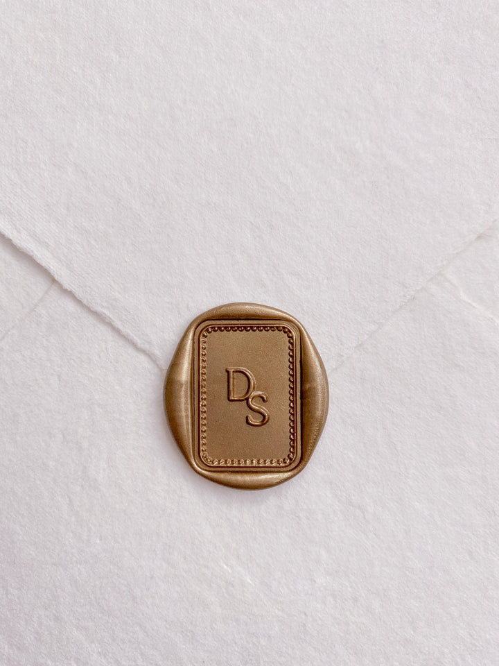 Border monogram rectangular custom wax seal in gold on beige handmade paper envelope