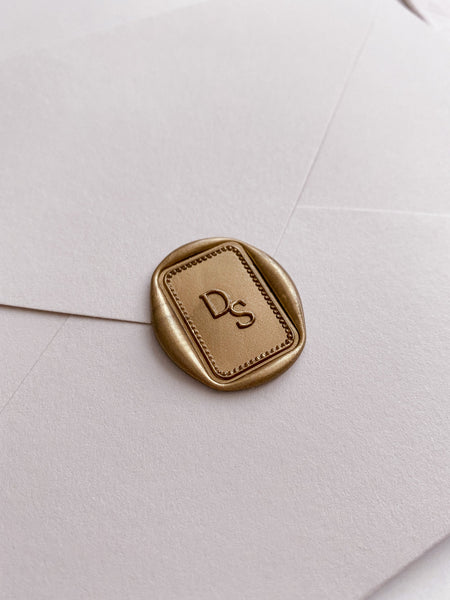Monogram with border design rectangular wax seal in gold on paper envelope_side angle