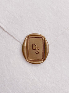 Monogram with border design rectangular wax seal in gold on handmade paper envelope_front angle