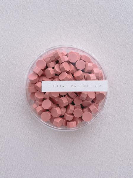a box of coral color sealing wax beads 