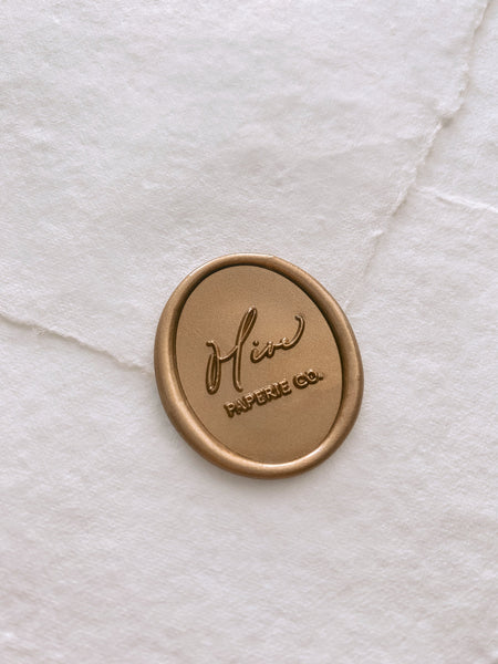Olive Paperie Co logo custom wax seal in gold on white handmade paper envelope