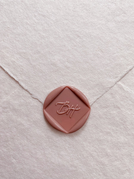 Calligraphy script monogram diamond shaped dusty rose custom wax seal on beige handmade paper envelope