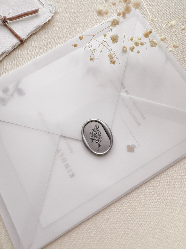 Oval arch shaped leaf design silver wax seal on a vellum wedding invitation envleope