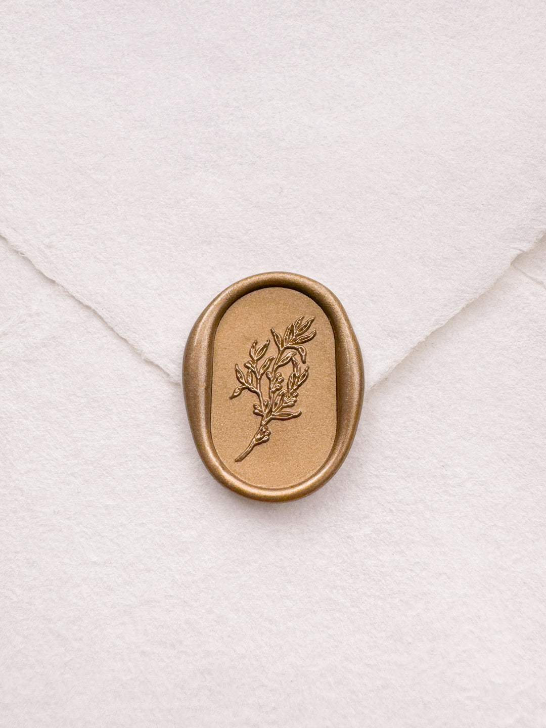 gold leaf design oval botanical wax seal on a white envelope