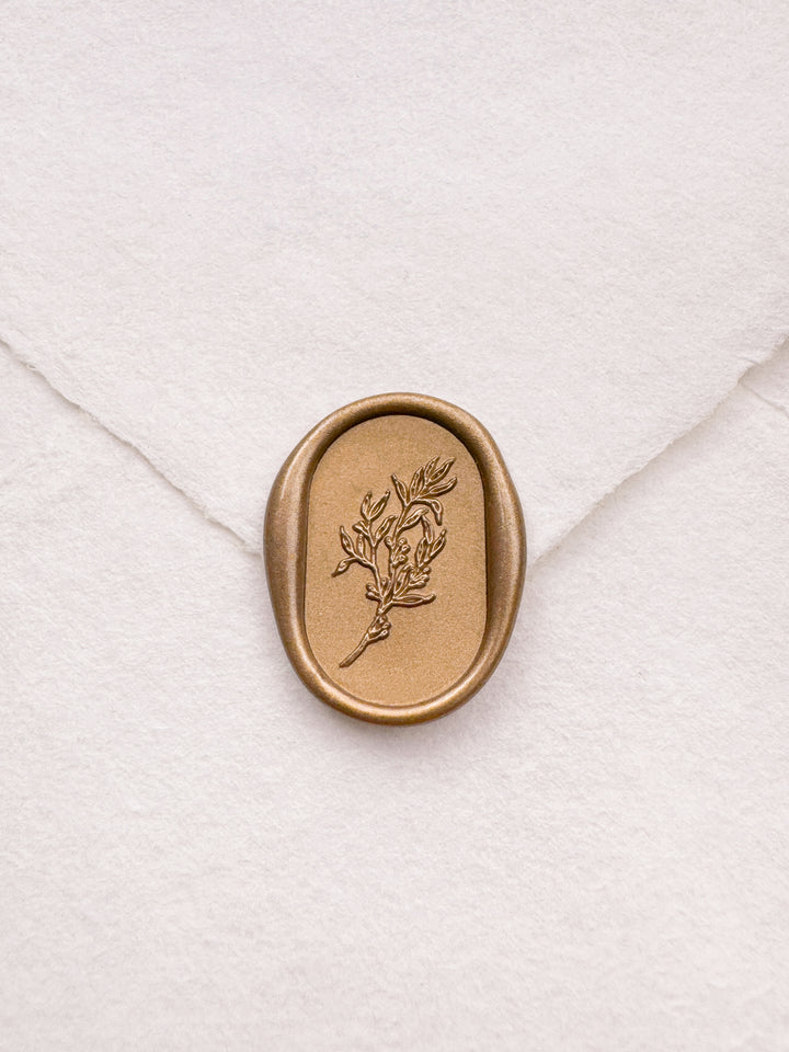 gold leaf design oval botanical wax seal on a white envelope