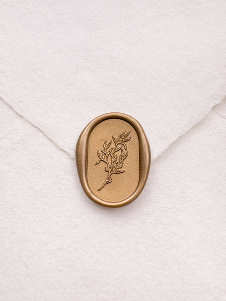 gold leaf design oval botanical wax seal on a white envelope