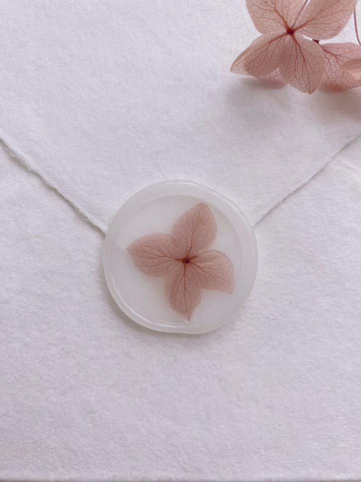 Pale mauve color dried hydrangea petal on clear color wax seal
