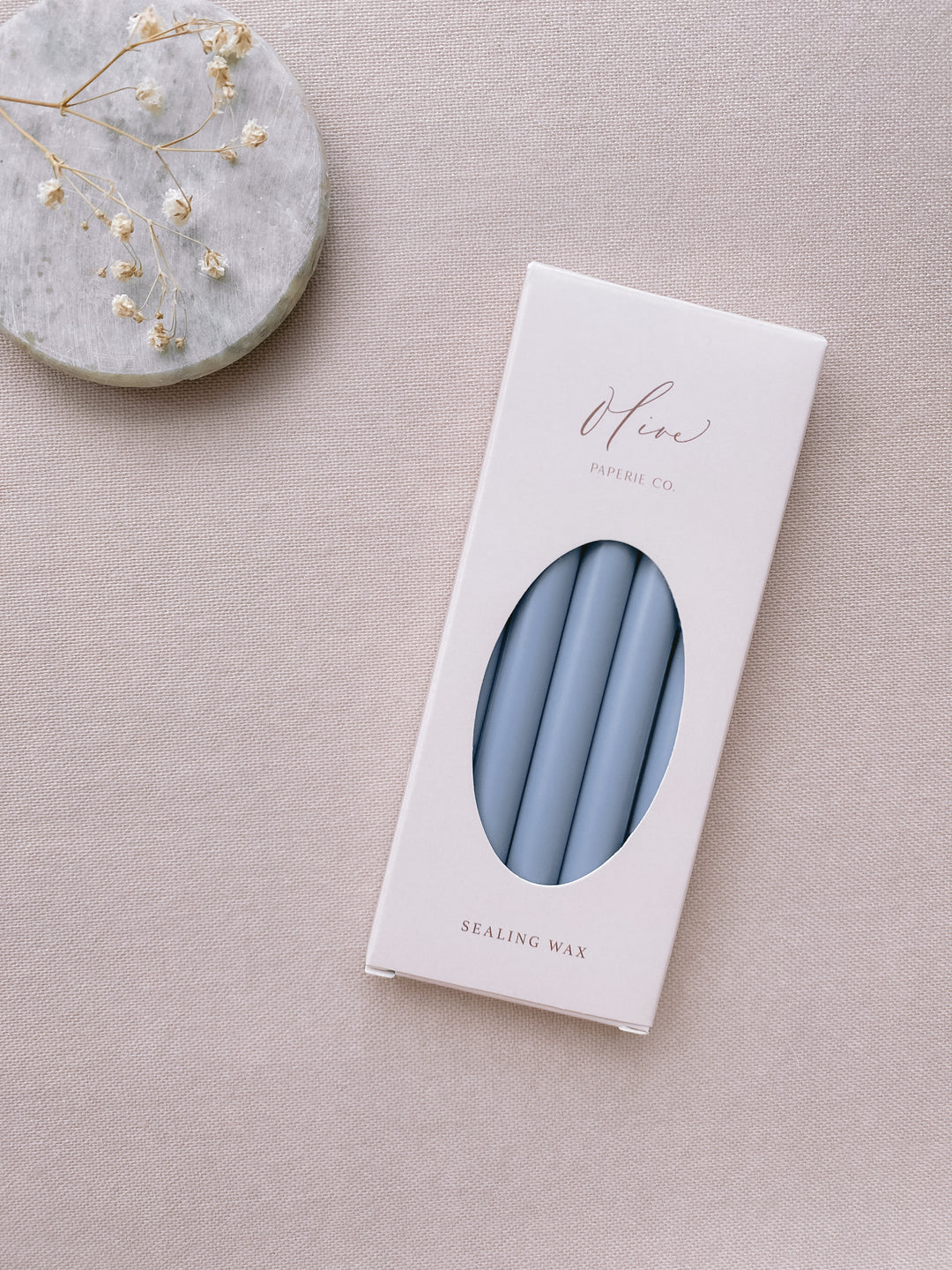 a box of 5 sealing glue gun wax sticks in dusty blue styled with small gray stone dish and dried flowers