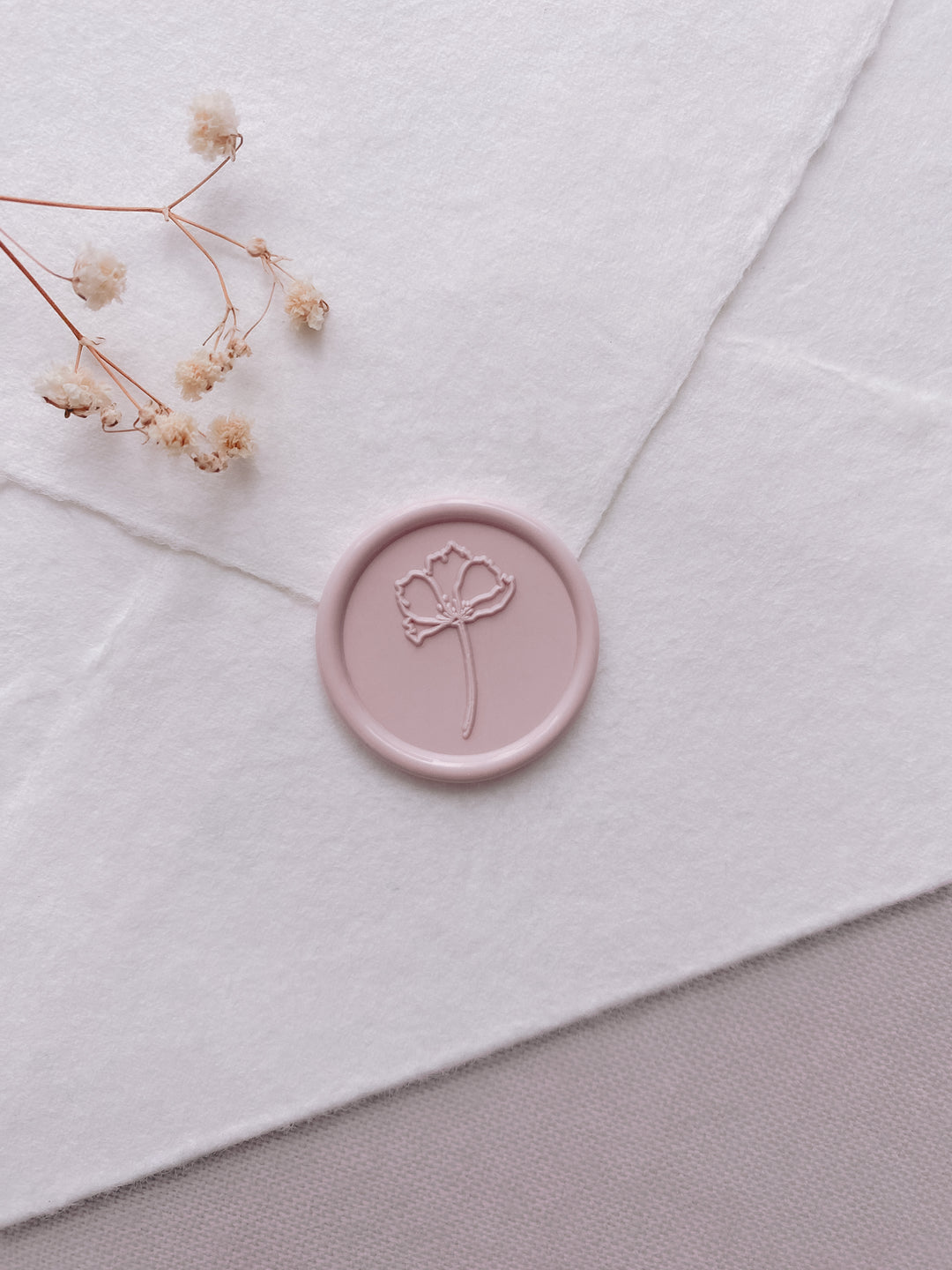 dusty nude simple flower wax seal on a white handmade paper envelope