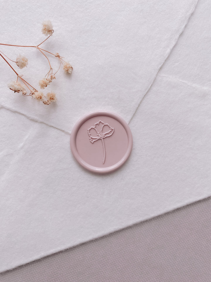 dusty nude simple flower wax seal on a white handmade paper envelope