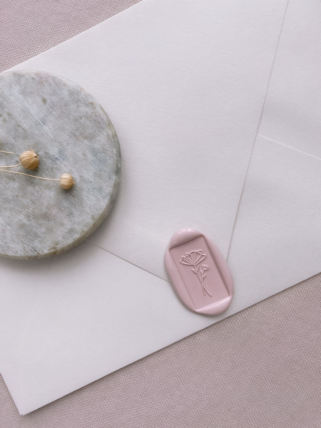 dusty nude rectangular abstract flower wax seal on beige envelope_side angle