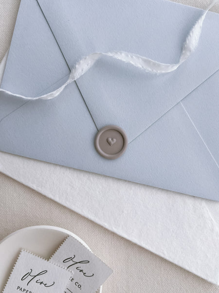 soft taupe 3D heart design mini wax seal on a light blue envelope
