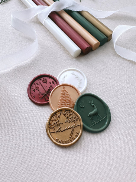 Christmas wax seals featuring designs such as Merry Christmas, reindeer, Christmas tree, wreath and festive ornaments in festive wax colors such as red, gold, green and white