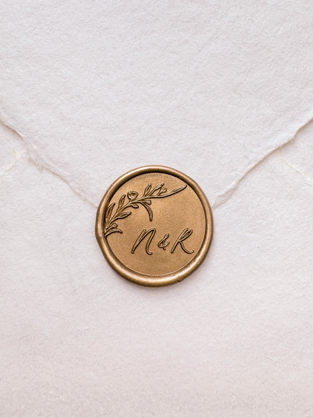 personalized initials botanical flower branch gold wax seal on a white envelope