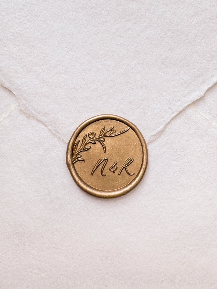 personalized initials botanical flower branch gold wax seal on a white envelope