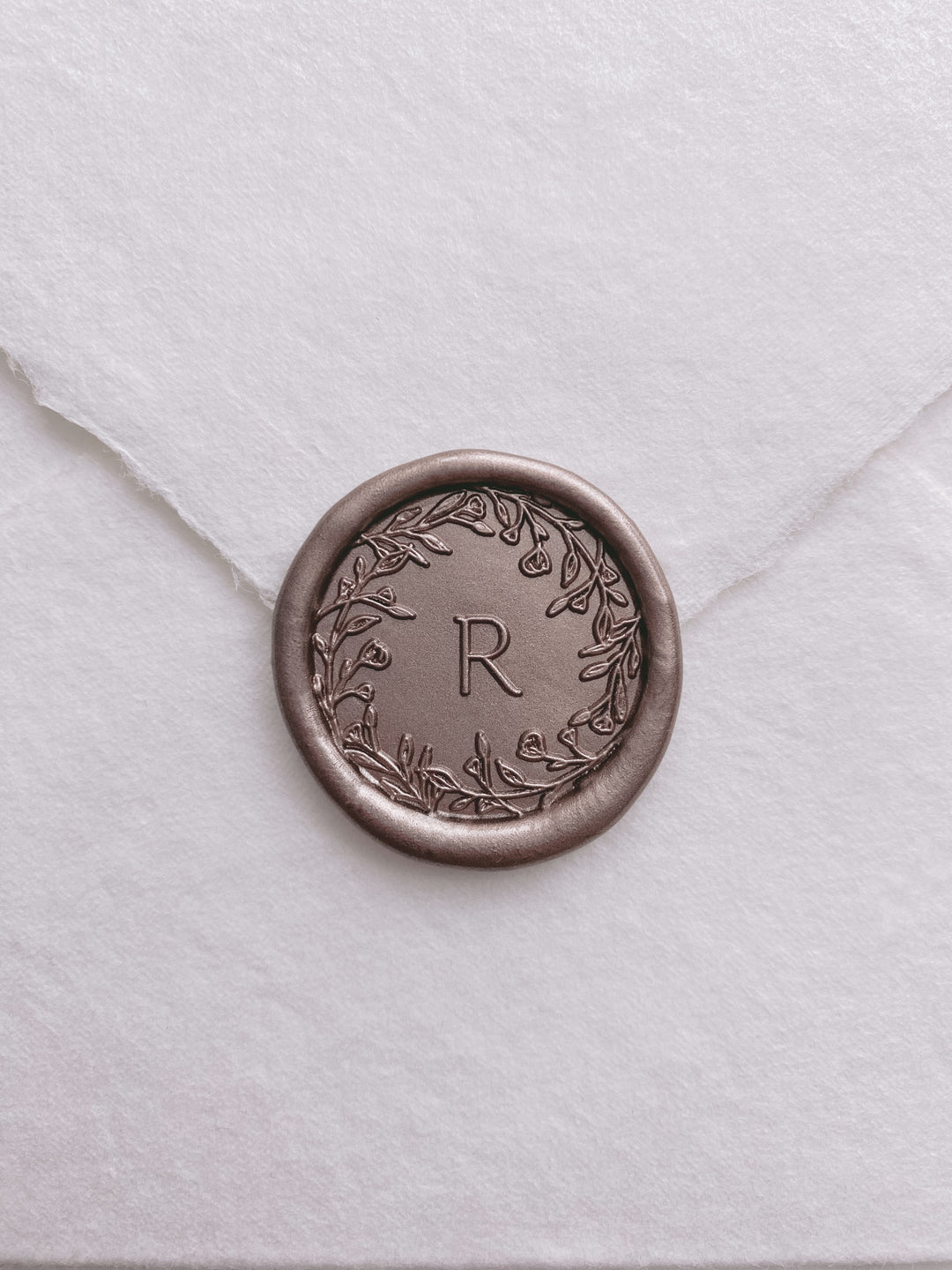 Floral crown single initial custom wax seal in color mocha on a white handmade paper envelope