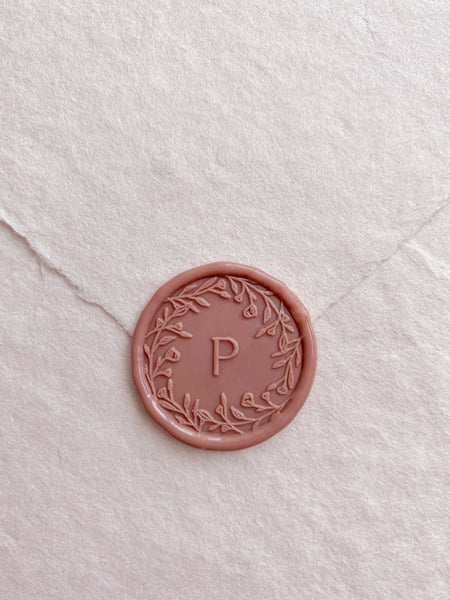 Floral crown single initial wax seal in dusty rose on handmade paper envelope_front angle