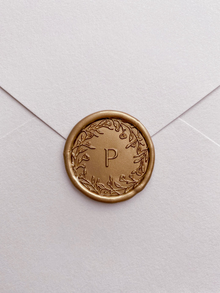 Floral crown single initial gold custom wax seal on beige paper envelope