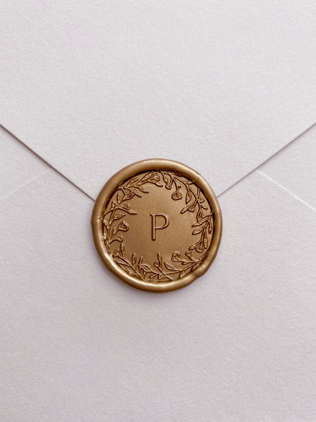 Floral crown single initial gold custom wax seal on beige paper envelope