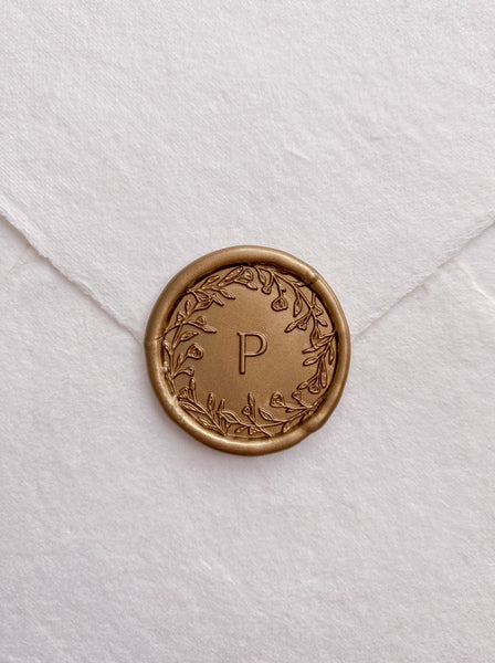 Floral crown single initial wax seal in gold on handmade paper envelope_front angle