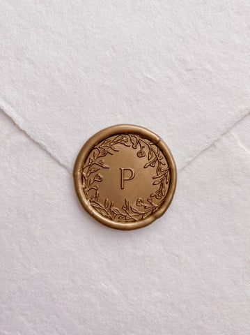 Floral crown single initial gold custom wax seal on beige handmade paper envelope