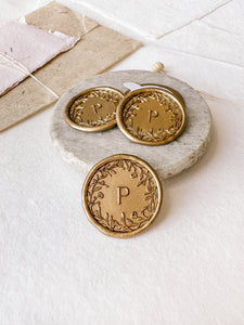 Floral crown single initial custom wax seals in gold styled with a small gray stone dish, handmade paper and a dried floral branch